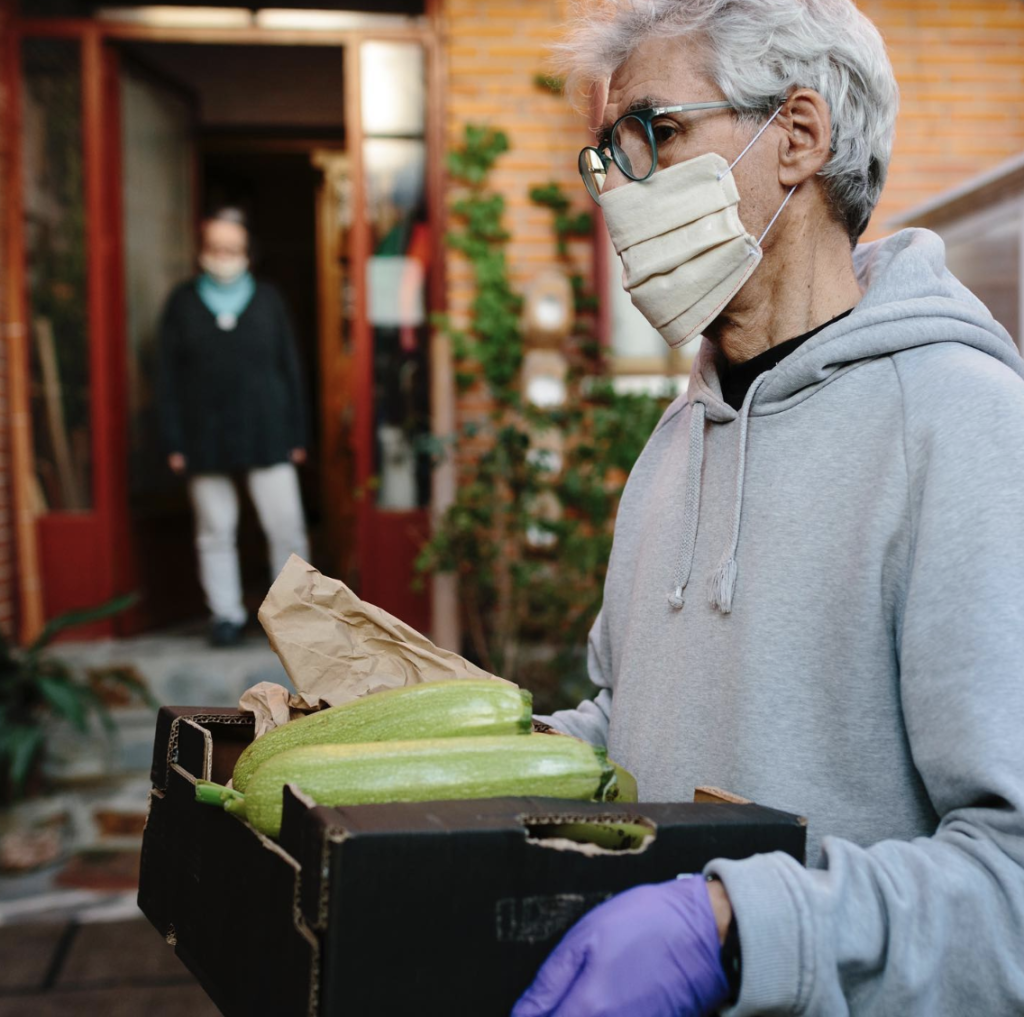 Person carrying groceries for their neighbor during COVID